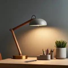 Stylowa lampka biurkowa z drewnianym ramieniem i betonową osłoną, oświetlająca miejsce pracy. Idealna do zadań wymagających precyzji, zapewnia odpowiednią ilość lumenów na m2.