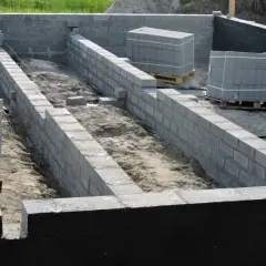 Budowa fundamentów z bloczków betonowych, przygotowanie pod izolację pionową fundamentów.