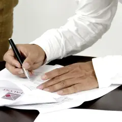 Podpisanie dokumentu, który może być aktem własności, przez mężczyznę w białej koszuli.