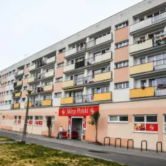 Długi blok mieszkalny z balkonami i sklepem "Sklep Polski" na parterze. Może to być najdłuższy blok w Polsce.