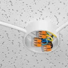 Nowe złącza WAGO ułatwiają wymianę instalacji elektrycznej. Biała puszka sufitowa z kolorowymi przewodami i pomarańczowymi zaciskami.