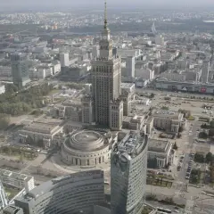 Widok z lotu ptaka na centrum Warszawy, gdzie widać Pałac Kultury i Nauki, jeden z najwyższych budynków w Polsce, otoczony nowoczesnymi wieżowcami.