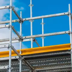 Metalowe rusztowanie budowlane na tle błękitnego nieba. Sprawdź, jaka jest aktualna wynajem rusztowania cena i zacznij budowę!
