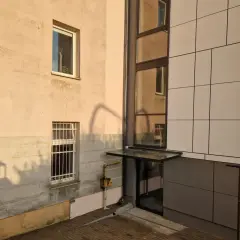 Nowoczesny blok z jasną elewacją i przeszklonym wejściem. Poznaj, jak zapisać adres mieszkania w bloku, by listonosz go odnalazł.
