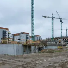 Budowa osiedla mieszkaniowego, gdzieś tu może być odpowiedź, jak dostać mieszkanie z wojska. Dźwigi i budynki w tle.
