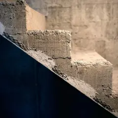 Surowe schody betonowe, idealne do rozważenia, jak tanio wykończyć schody betonowe. Widoczne nierówności i siatka zbrojeniowa.