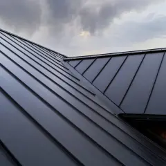 Nowoczesny, czarny dach z blachy, przypominający łuskę smoka, chroni dom. Styropapa pod nim zapewnia izolację.