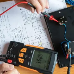 Pomiar rezystancji izolacji. Multimetr pokazuje 0.855 V, a ręka trzyma sondę do pomiaru.