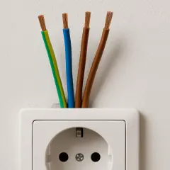 Cztery przewody wychodzące z gniazdka elektrycznego. Zastanawiasz się, jaki kabel do indukcji będzie najlepszy?
