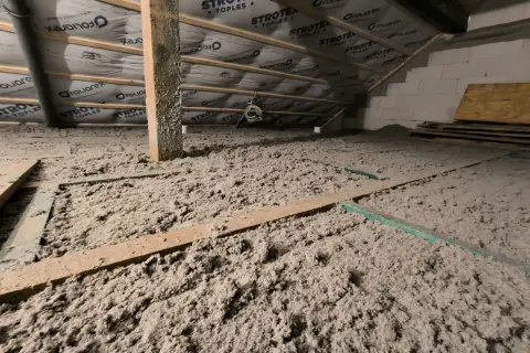 Podłoga strychu pokryta grubą warstwą celulozowego materiału izolacyjnego. Ocieplanie celulozą to ekologiczne rozwiązanie.