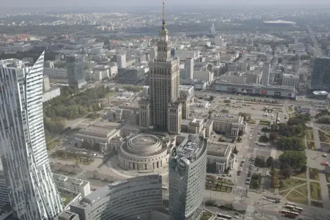 Widok z lotu ptaka na centrum Warszawy, gdzie widać Pałac Kultury i Nauki, jeden z najwyższych budynków w Polsce, otoczony nowoczesnymi wieżowcami.