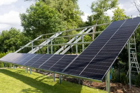 Montaż paneli fotowoltaicznych na stelażu. Instalacja PV w ogrodzie, gotowa do produkcji czystej energii.