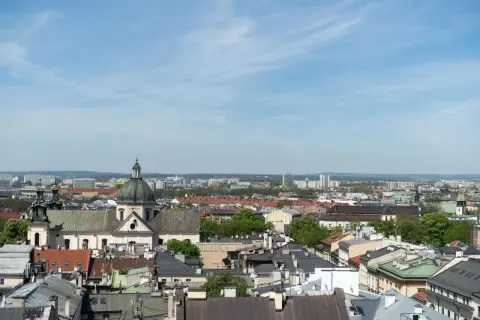Widok na krakowskie dachy i kościół z kopułą. W tle nowoczesne budynki, które mogą wpływać na ceny mieszkań Kraków.