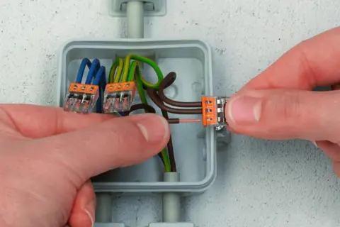Pokazano, jak stosować złączki Wago do połączenia przewodów elektrycznych w puszce.