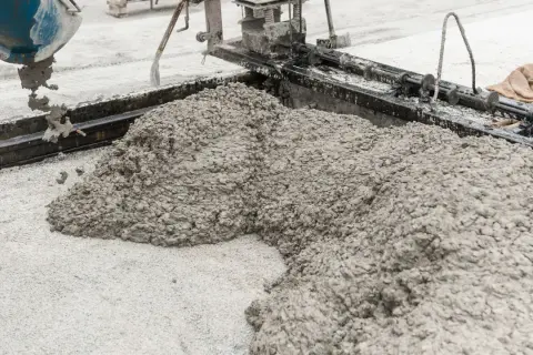 Świeża podsypka cementowo piaskowa wylewana z betoniarki na plac budowy.