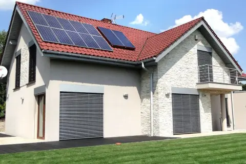 Nowoczesny dom z panelami solarnymi na dachu. Elegancka elewacja i zadbany ogród.