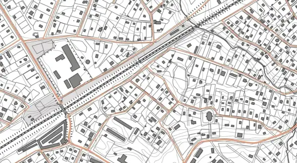 Szczegółowa mapa sytuacyjno wysokościowa z zaznaczonymi budynkami, drogami i liniami kolejowymi.
