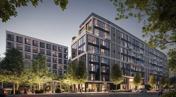 Nowoczesny apartamentowiec z przeszklonymi fasadami i zielonymi tarasami, otoczony drzewami.