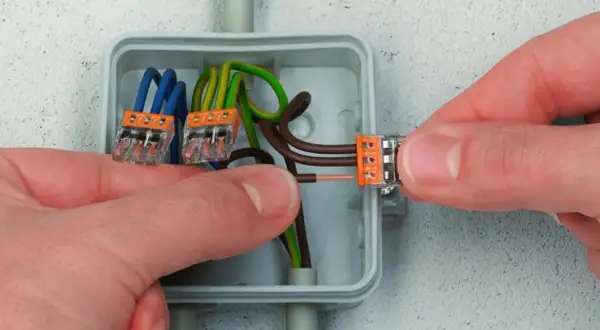 Pokazano, jak stosować złączki Wago do połączenia przewodów elektrycznych w puszce.