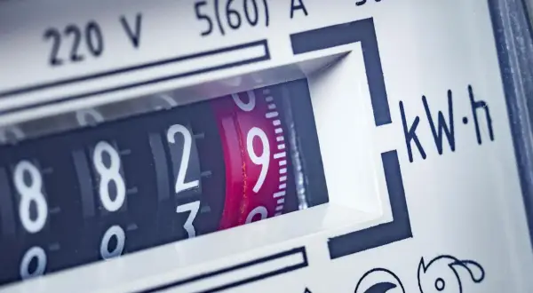 Zbliżenie na licznik energii elektrycznej, pokazujący aktualne zużycie prądu. Widoczne cyfry 8829 i oznaczenie kWh.
