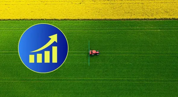 Wykres wzrostu na tle pola rzepaku i zielonej łąki, gdzie pracuje traktor. Zastanawiasz się, ile kosztuje hektar ziemi?