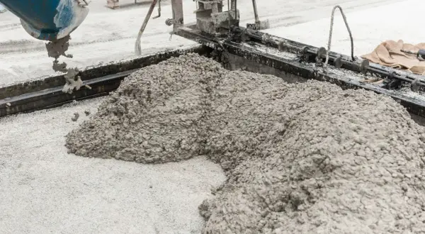 Świeża podsypka cementowo piaskowa wylewana z betoniarki na plac budowy.