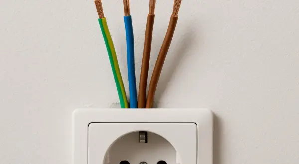 Cztery przewody wychodzące z gniazdka elektrycznego. Zastanawiasz się, jaki kabel do indukcji będzie najlepszy?