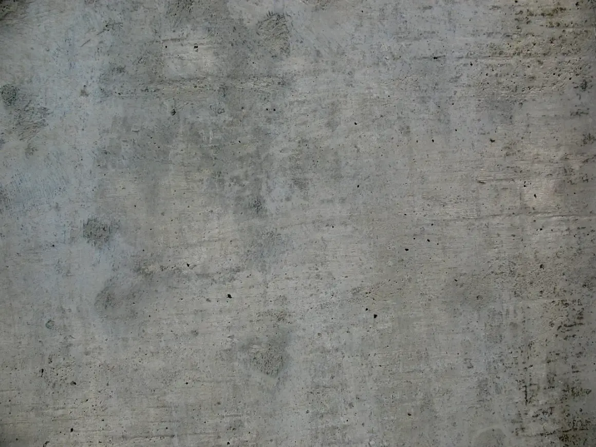 Szara, chropowata powierzchnia betonu w8, z widocznymi śladami po szalunkach i drobnymi porami.