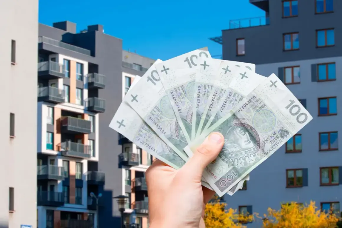 Dłoń trzyma polskie banknoty 100 zł na tle nowoczesnych bloków mieszkalnych. Szybka sprzedaż mieszkania przed upływem 5 lat.