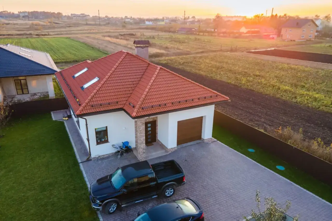 Nowy dom z podjazdem i samochodami. Rodzice pomogli w zakupie, co może wiązać się z darowizną od rodziców i kwestią podatek.