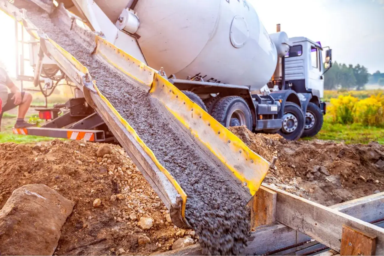 Betoniarka wylewa beton na budowie. Zastanawiasz się, ile kosztuje kubik betonu?