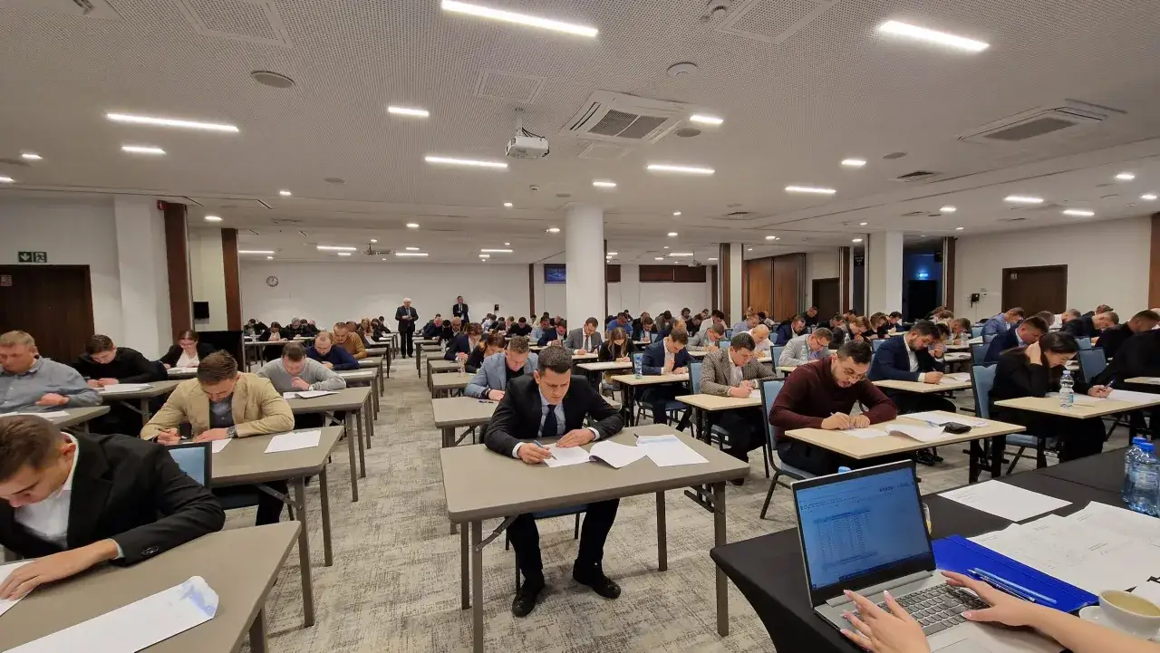 Uczestnicy egzaminu na uprawnienia budowlane elektryczne skupieni na zadaniach.