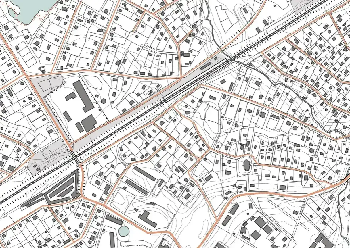 Szczegółowa mapa sytuacyjno wysokościowa z zaznaczonymi budynkami, drogami i liniami konturowymi. Widać fragment zabudowy miejskiej i terenów zielonych.