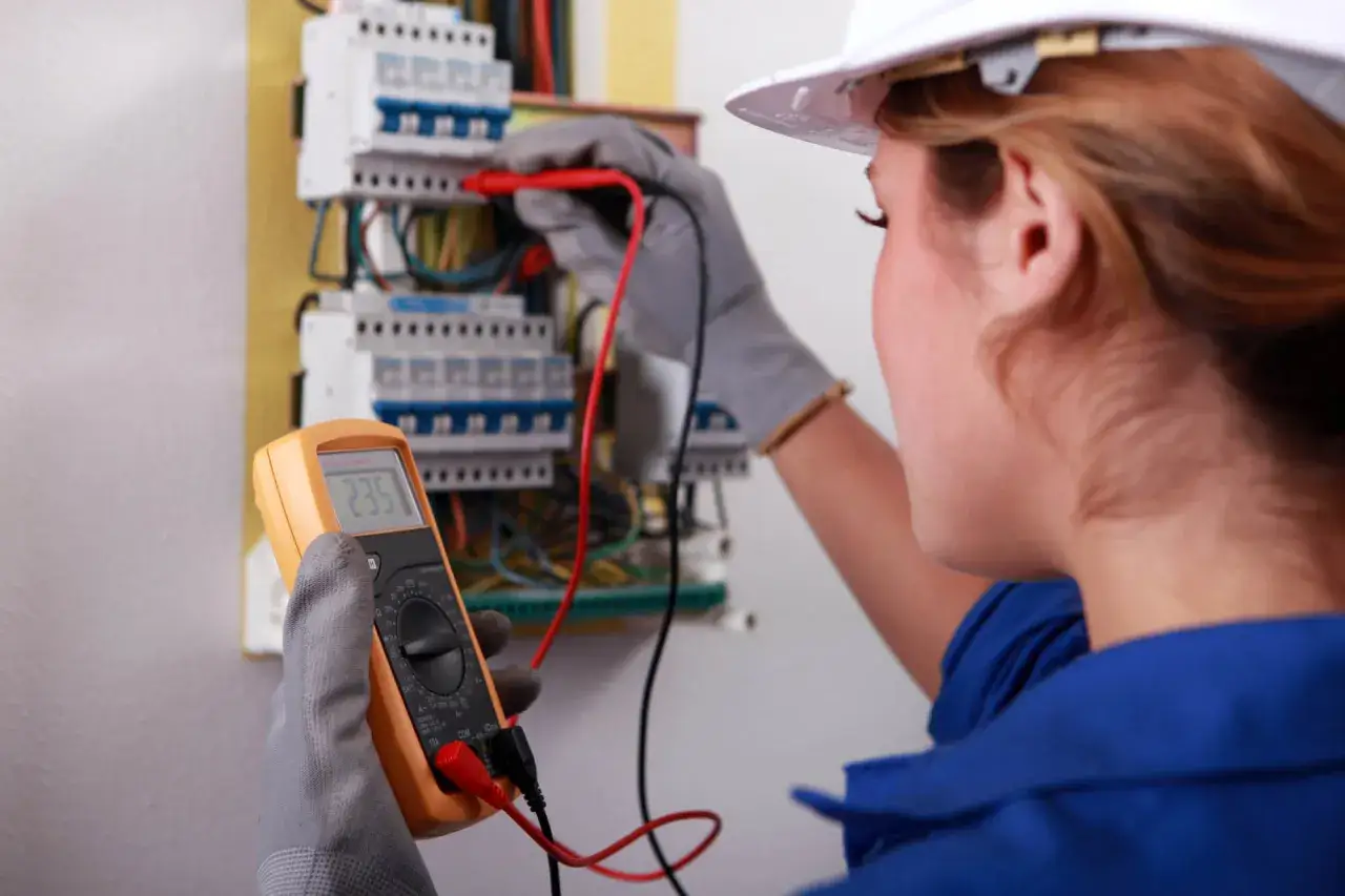Elektryk sprawdza napięcie multimetrem. Sprawdź nasz cennik pomiary elektryczne.