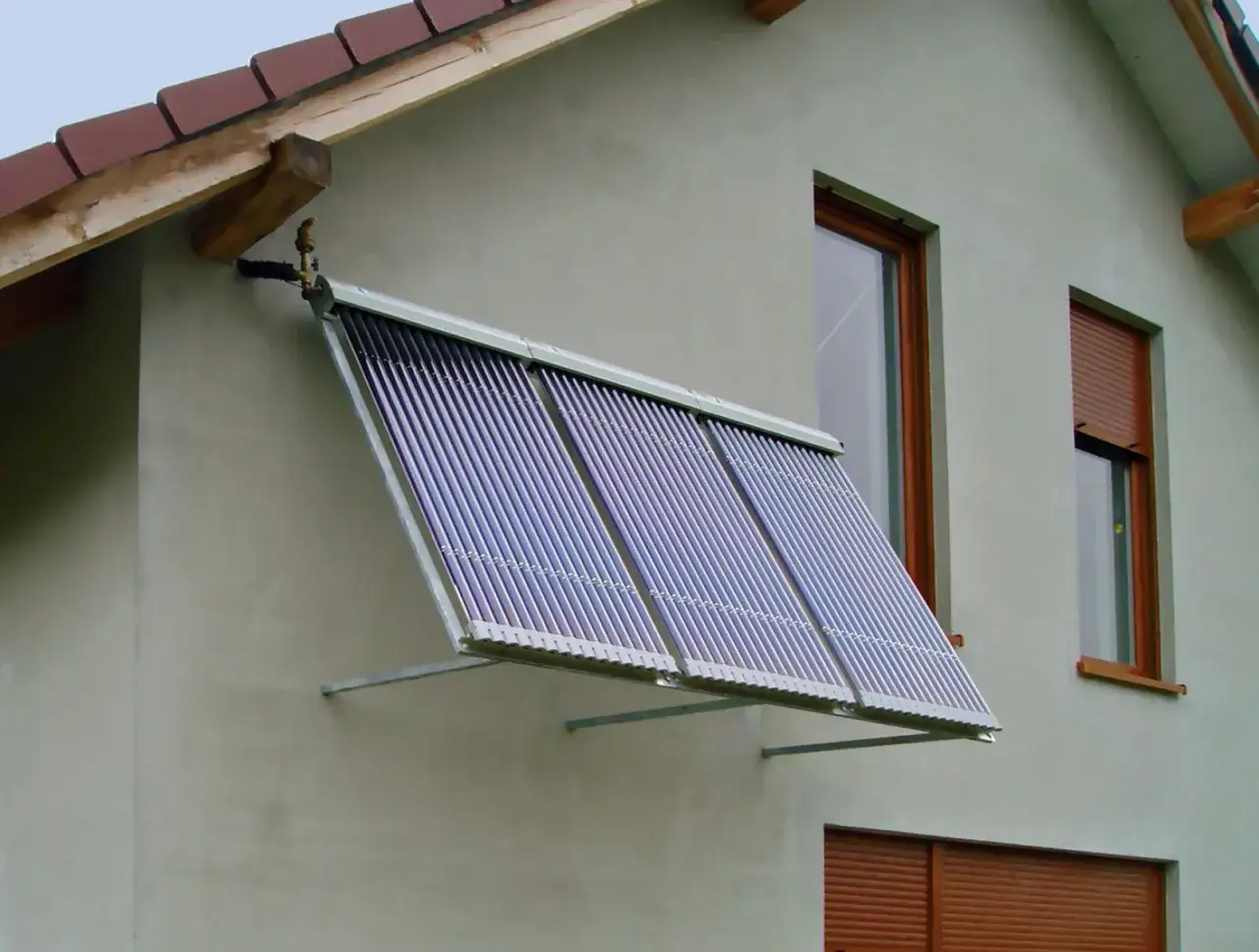 Kolektory solary na ścianie domu, zbierające energię słoneczną.