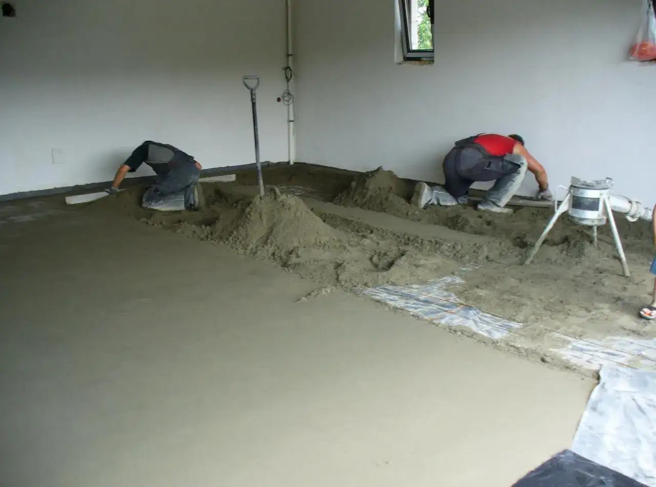 Pracownicy wykonują wylewkę betonową. Sprawdzają cenę za m2 robocizny bez materiału, by zaplanować budżet.