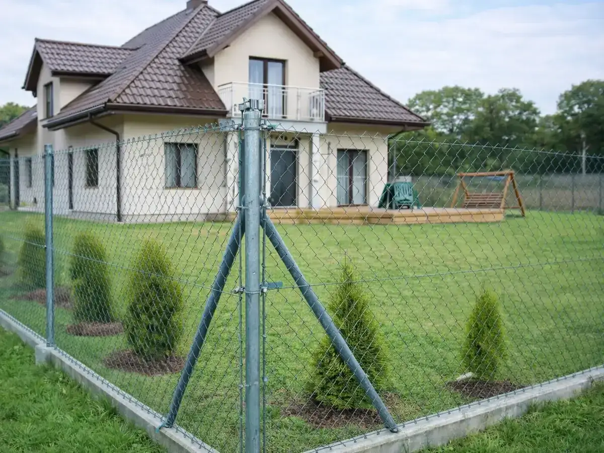 Nowoczesne ogrodzenie domu z siatki. Zastanawiasz się, ile kosztuje metr siatki ogrodzeniowej?