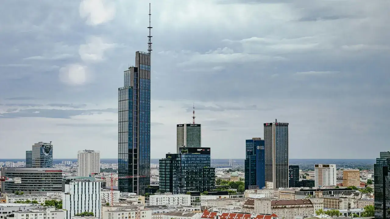 Warszawski krajobraz zdominowany przez najwyższe budynki w Polsce, w tym wieżowiec z anteną.