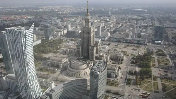 Widok z lotu ptaka na centrum Warszawy, gdzie widać Pałac Kultury i Nauki, jeden z najwyższych budynków w Polsce, otoczony nowoczesnymi wieżowcami.