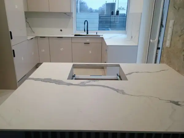 Nowoczesna kuchnia z wyspą i blatem z spieku kwarcowego. Sprawdź spiek kwarcowy cena za m2, by stworzyć podobne wnętrze.
