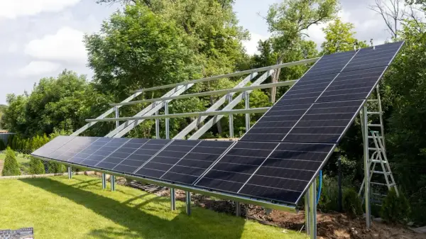 Montaż paneli fotowoltaicznych na stelażu. Instalacja PV w ogrodzie, gotowa do produkcji czystej energii.