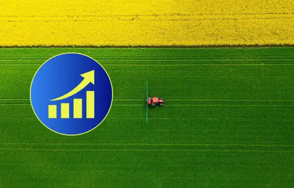 Wykres wzrostu na tle pola rzepaku i zielonej łąki, gdzie pracuje traktor. Zastanawiasz się, ile kosztuje hektar ziemi?