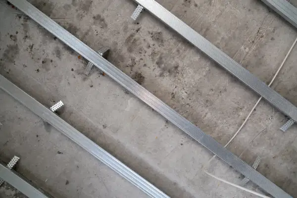 Metalowe profile sufitowe przymocowane do betonowego stropu, widok z góry.